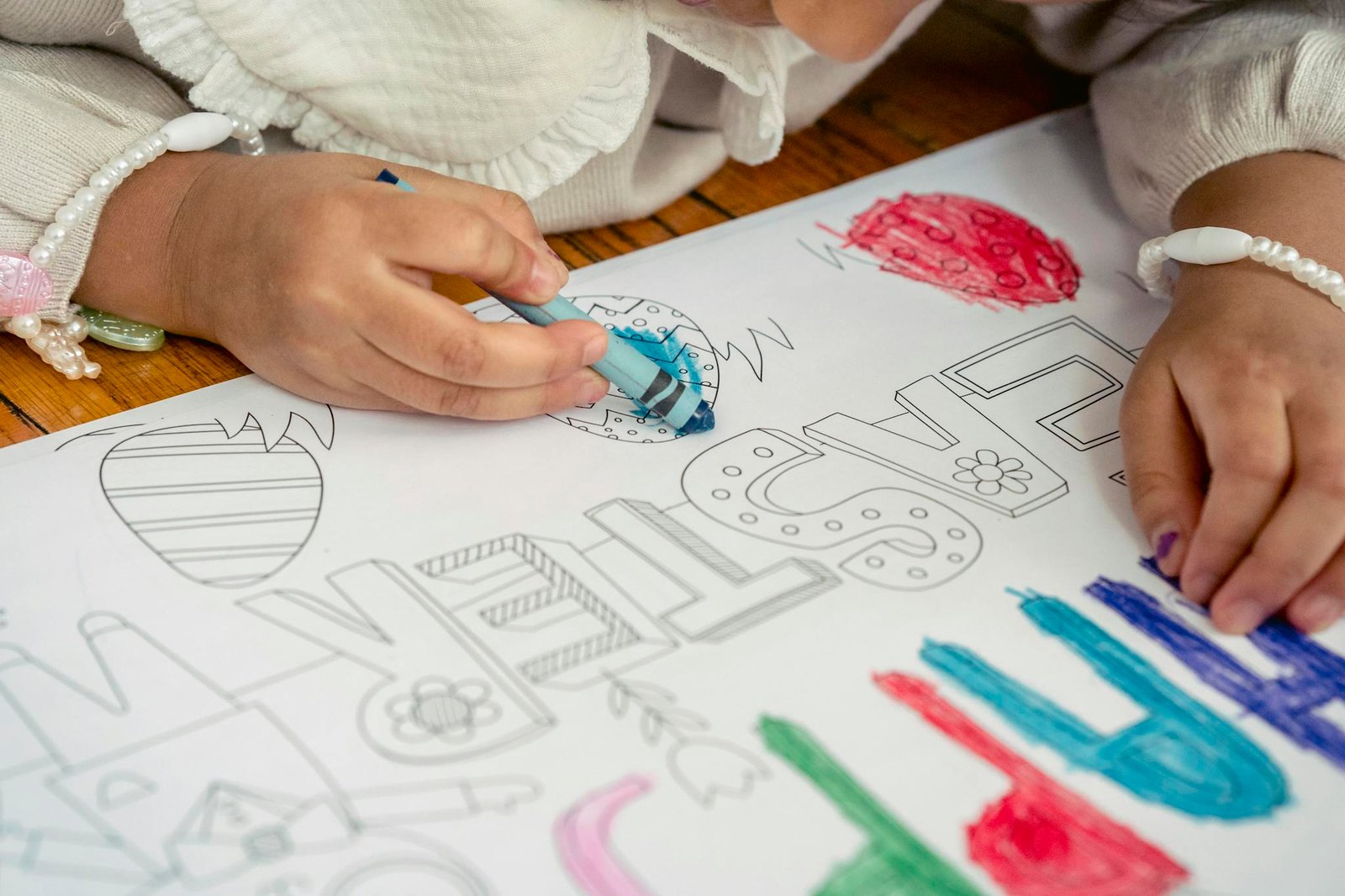 Young child coloring Easter-themed drawings with crayons, focusing on creativity and fun.